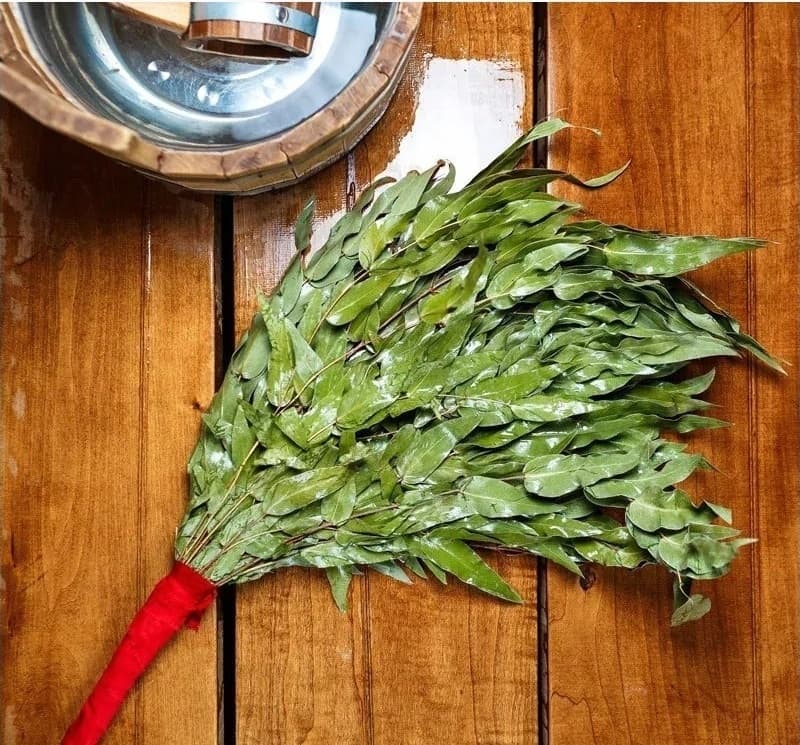 Prepared eucalyptus sauna whisk on a wooden surface